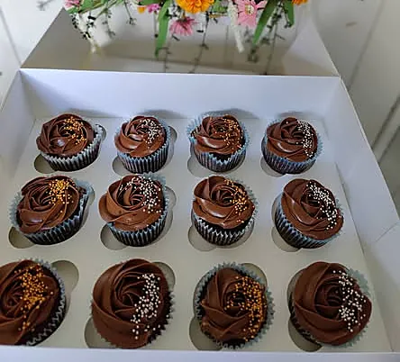 Eske med sjokoladecupcakes med sjokoladeglasur og strøssel